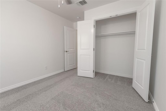 unfurnished bedroom with light carpet and a closet