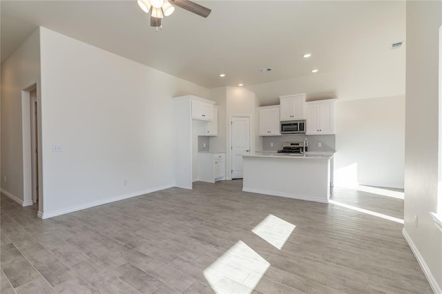 unfurnished living room featuring ceiling fan and light hardwood / wood-style floors