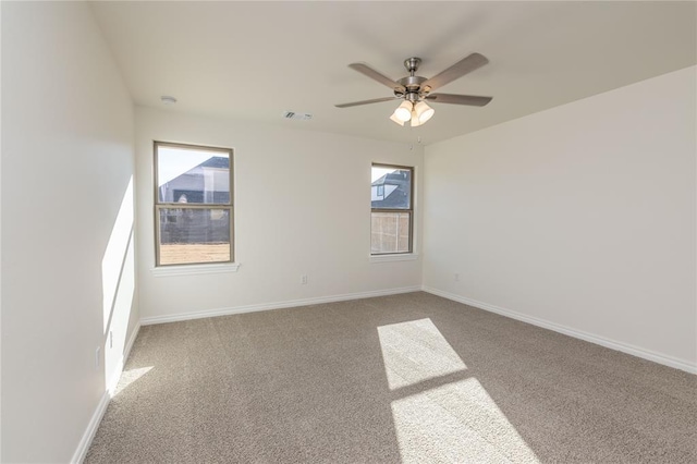 carpeted spare room with ceiling fan