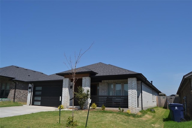 prairie-style home featuring a garage and a front lawn