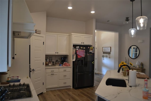 kitchen featuring black appliances, white cabinetry, hardwood / wood-style flooring, and tasteful backsplash