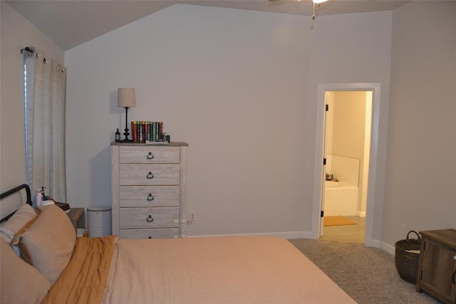 carpeted bedroom featuring ensuite bath and lofted ceiling