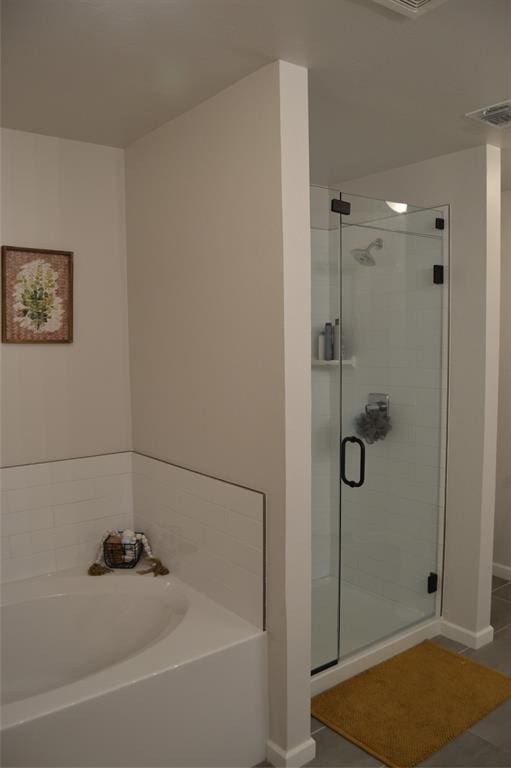 bathroom featuring tile patterned floors and separate shower and tub