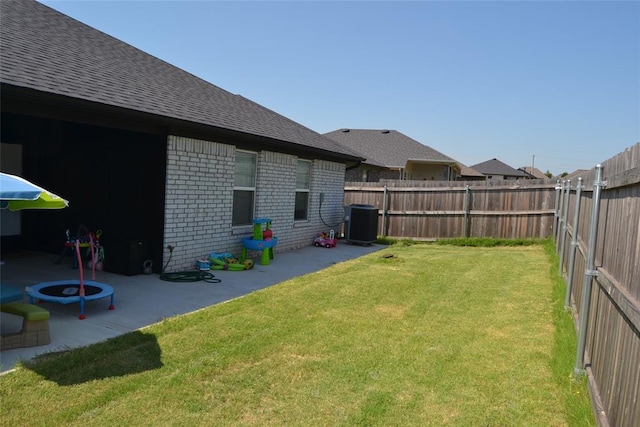 view of yard with central air condition unit and a patio