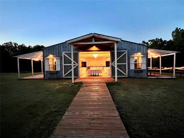 outdoor structure at dusk featuring a yard