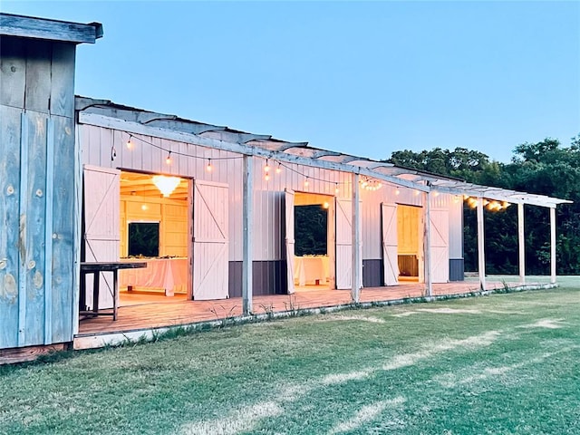 back of property featuring an outbuilding and a lawn