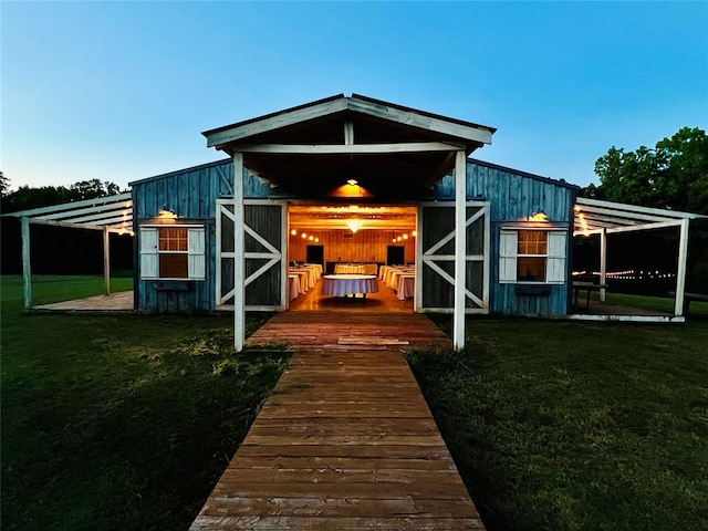 rear view of house featuring an outdoor structure and a lawn