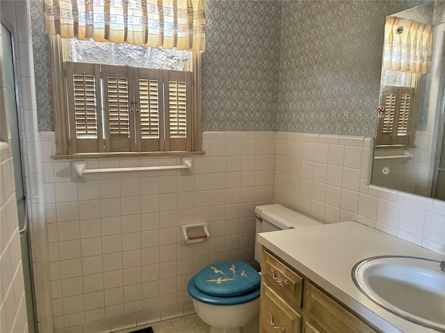 bathroom with vanity, toilet, and tile walls