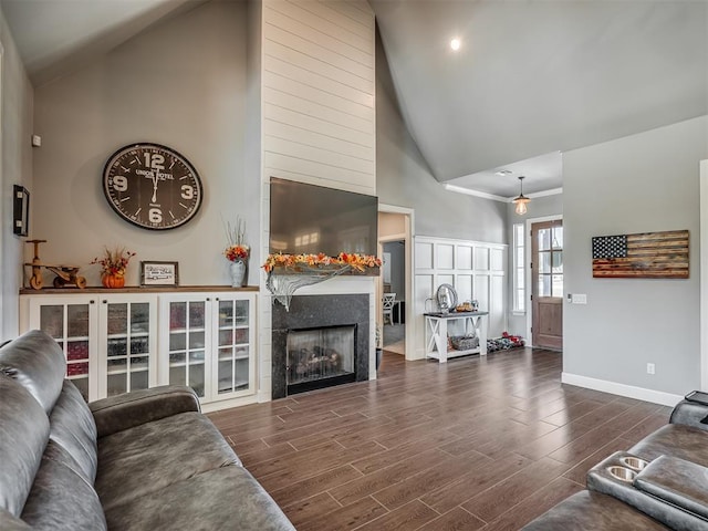 living room featuring high vaulted ceiling, dark wood-type flooring, and a tiled fireplace