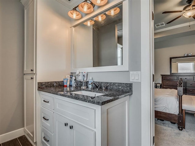 bathroom with wood-type flooring, vanity, ceiling fan, and ornamental molding