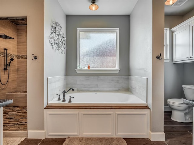 bathroom featuring wood-type flooring, toilet, and a bathtub