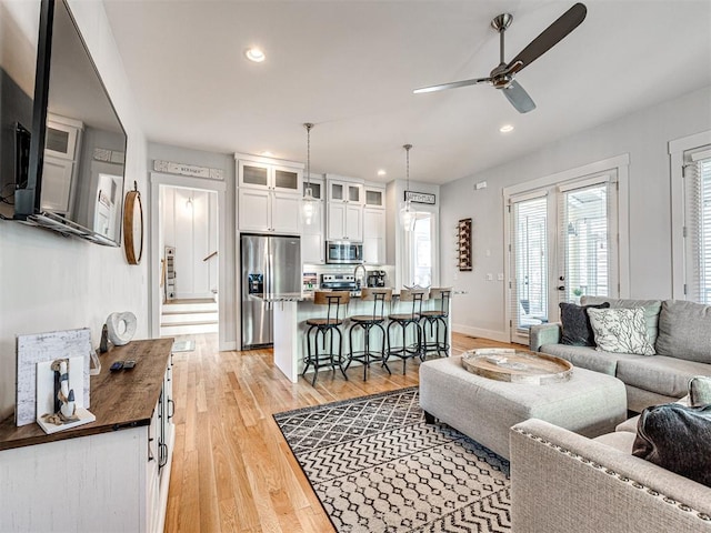 living room featuring ceiling fan and light wood-type flooring