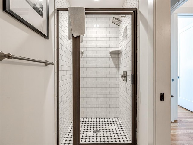 bathroom with wood-type flooring and an enclosed shower