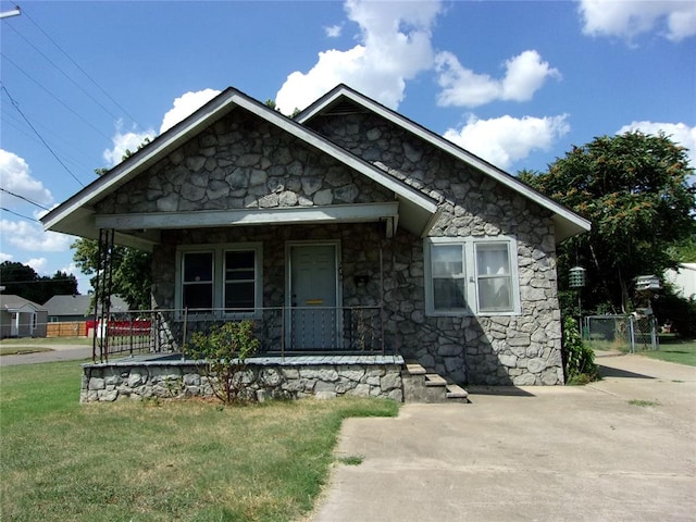 view of front of property featuring covered porch and a front yard