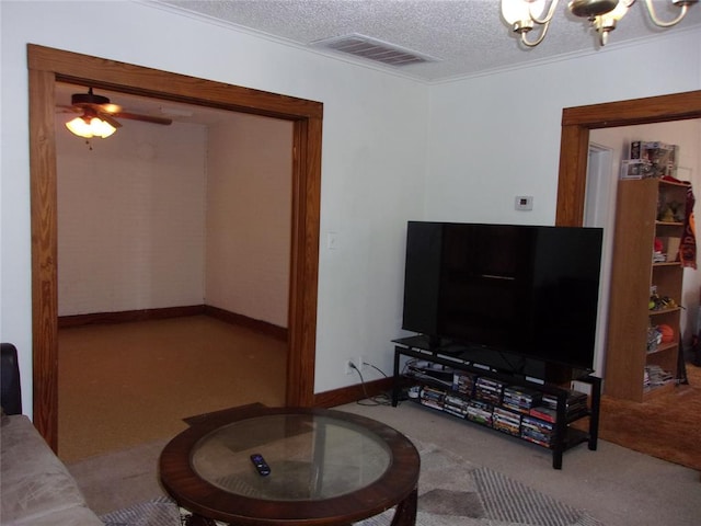 carpeted living area with ceiling fan with notable chandelier, baseboards, visible vents, and a textured ceiling