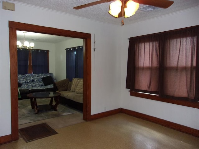 living area featuring ceiling fan with notable chandelier, visible vents, baseboards, and a textured ceiling