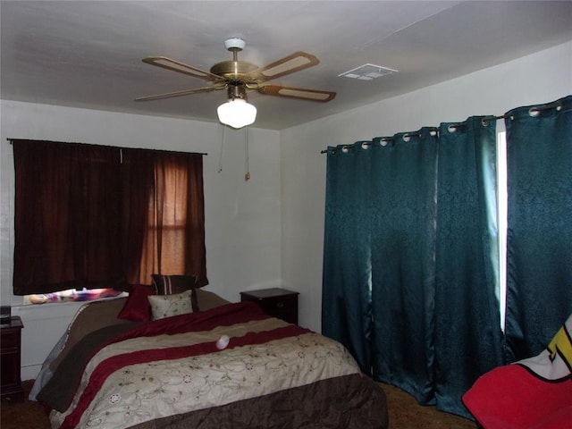 bedroom with carpet, a ceiling fan, and visible vents