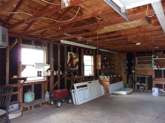 garage with an AC wall unit and a workshop area