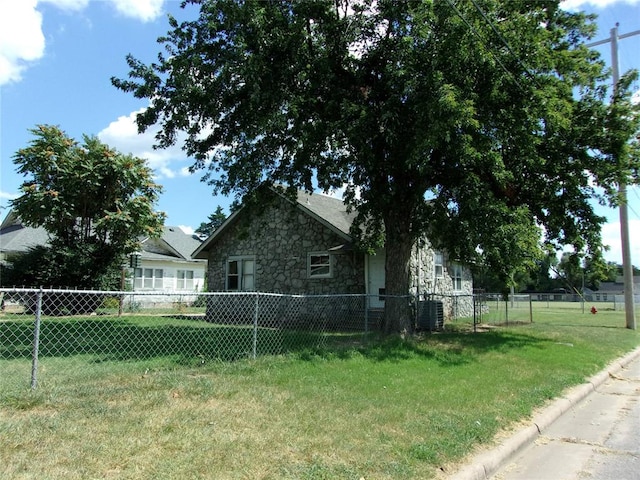 view of side of home featuring a yard, fence, stone siding, and cooling unit