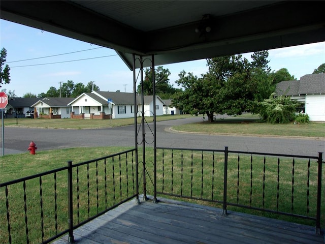 wooden terrace featuring a residential view and a yard