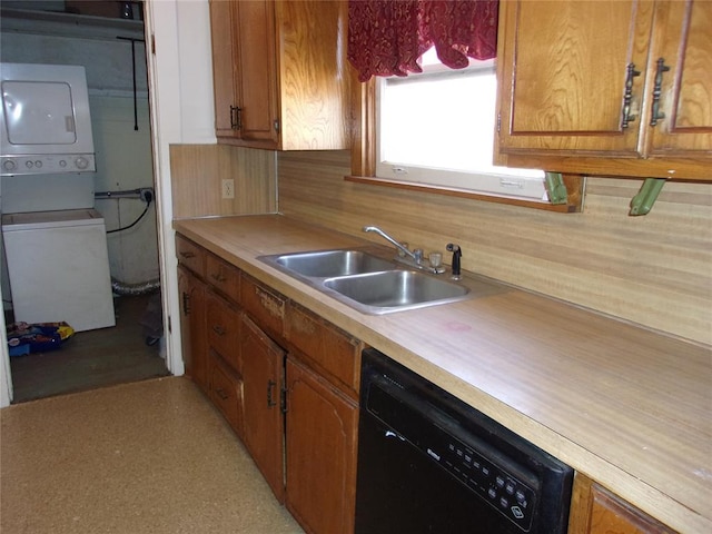 kitchen with a sink, dishwasher, light countertops, and stacked washer and clothes dryer