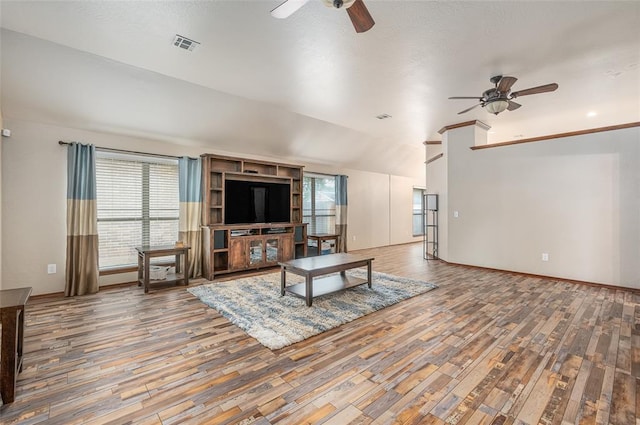 living room with ceiling fan, lofted ceiling, and hardwood / wood-style flooring