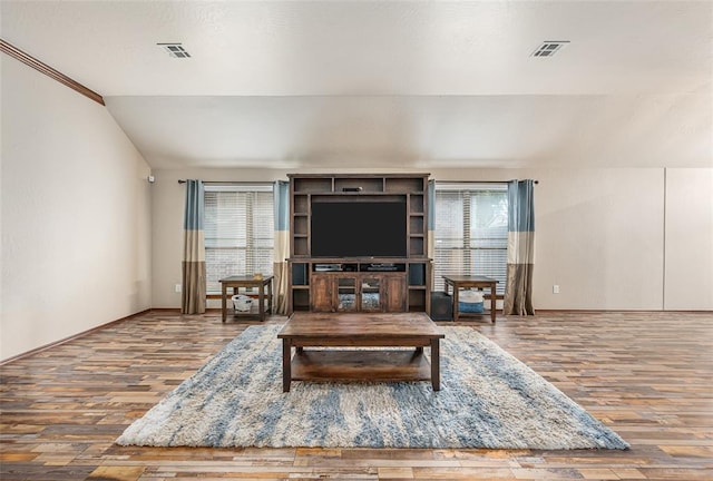 living room featuring hardwood / wood-style flooring, a wealth of natural light, and vaulted ceiling