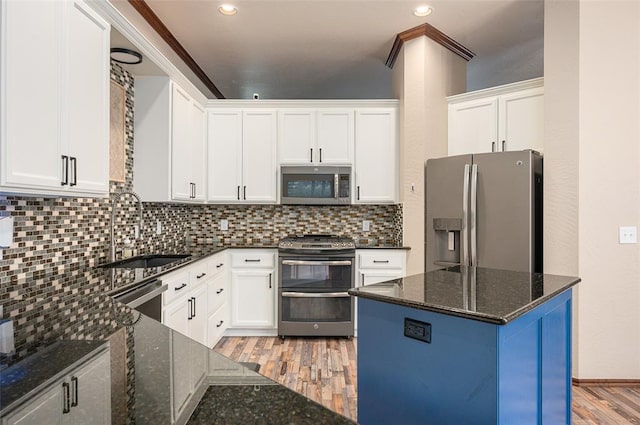 kitchen featuring dark stone counters, sink, white cabinets, and stainless steel appliances