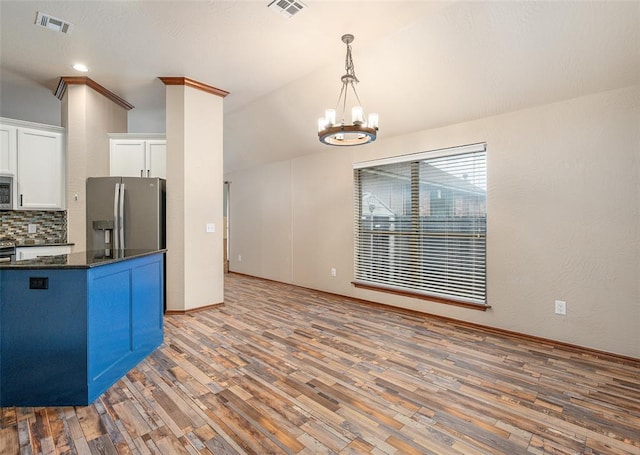 kitchen featuring hardwood / wood-style floors, decorative backsplash, pendant lighting, and stainless steel appliances