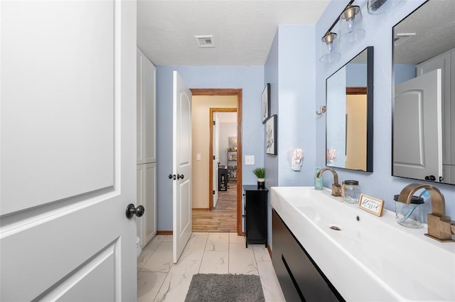 bathroom featuring a textured ceiling, vanity, and hardwood / wood-style floors