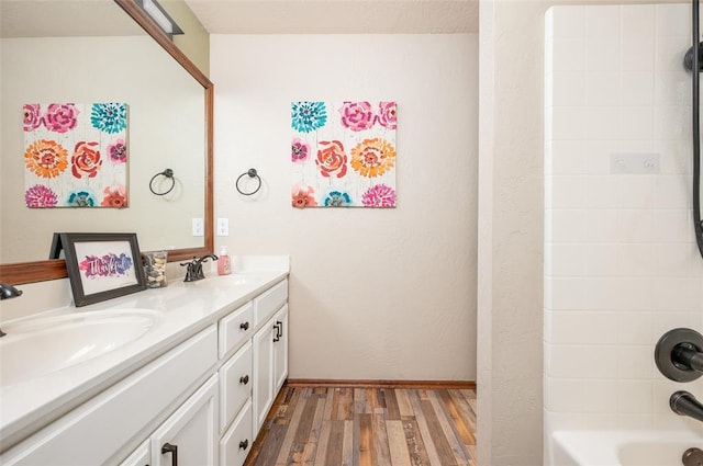 bathroom with hardwood / wood-style flooring, vanity, and bathtub / shower combination