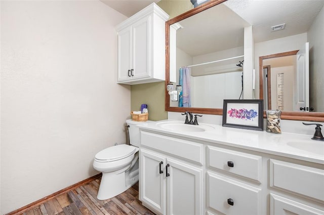 bathroom with hardwood / wood-style flooring, vanity, toilet, and a shower with curtain