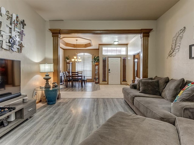 living room featuring light hardwood / wood-style flooring, a notable chandelier, and crown molding