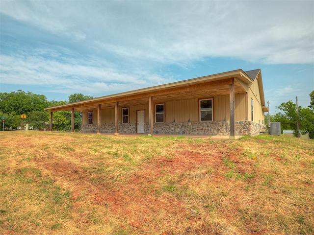 view of front of home with a front yard and cooling unit