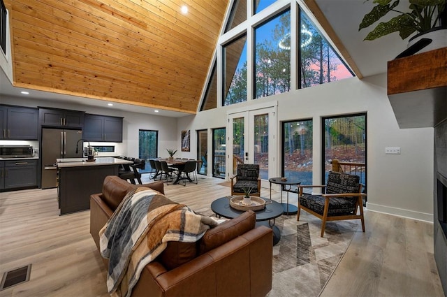 living room with french doors, light wood-type flooring, high vaulted ceiling, and wooden ceiling