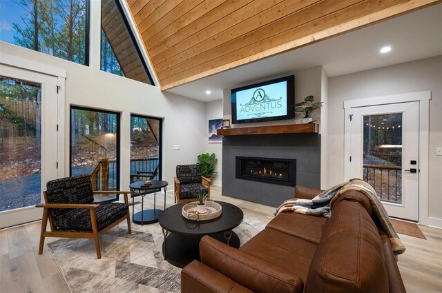 living room with light hardwood / wood-style flooring, high vaulted ceiling, and wood ceiling