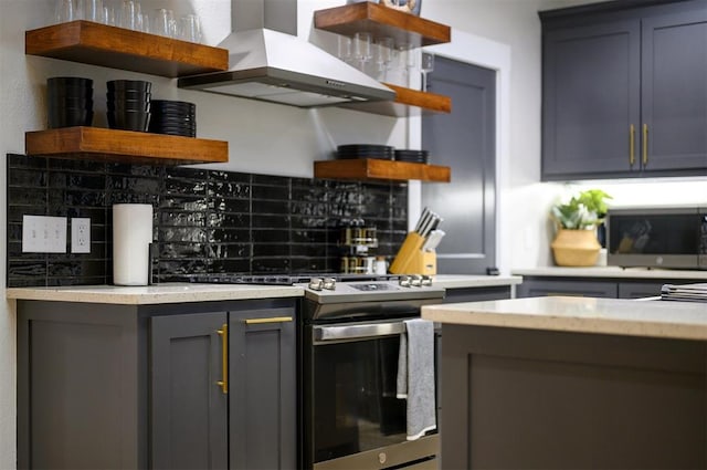 kitchen featuring backsplash, stainless steel appliances, gray cabinets, and wall chimney exhaust hood