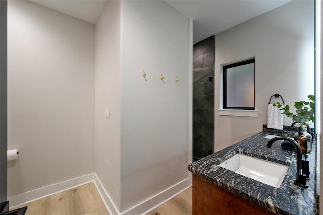 bathroom with vanity, wood-type flooring, and tiled shower