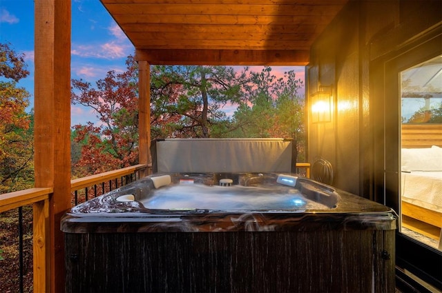 deck at dusk with a hot tub