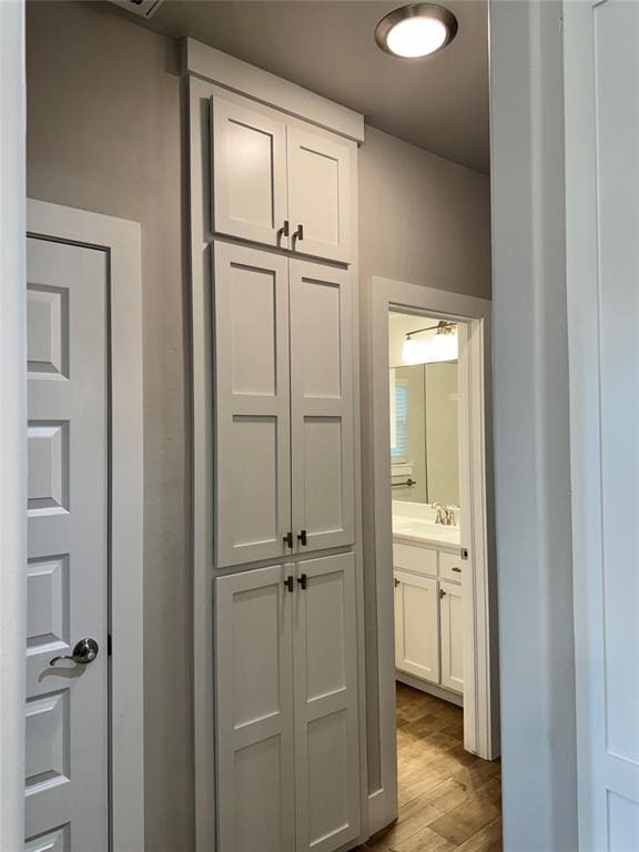 hallway with sink and light wood-type flooring