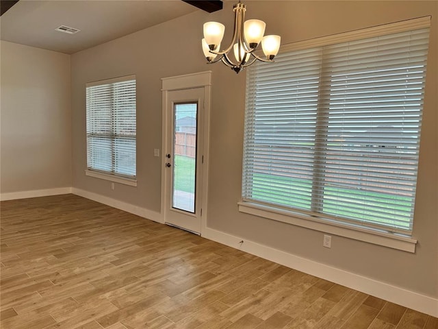 doorway to outside featuring hardwood / wood-style flooring, a chandelier, and plenty of natural light