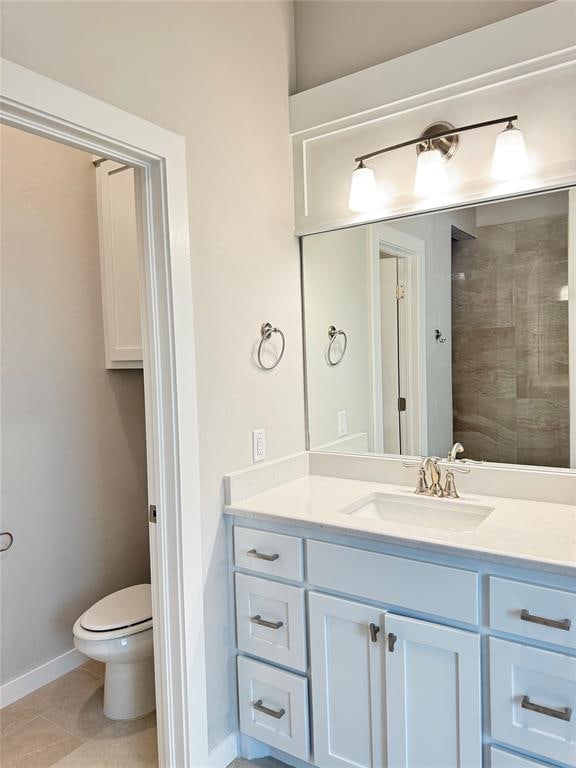 bathroom with vanity, toilet, and tile patterned flooring