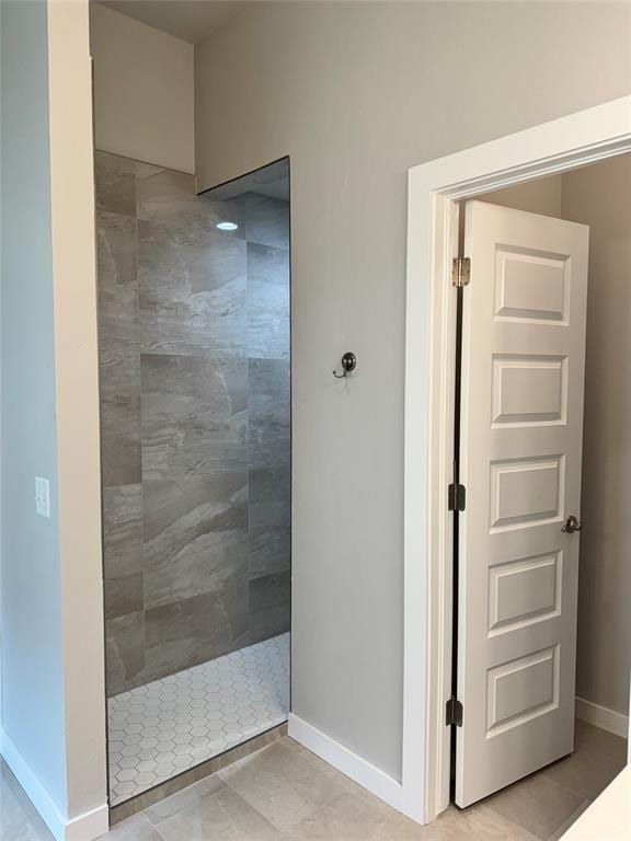 bathroom featuring a tile shower and tile patterned flooring