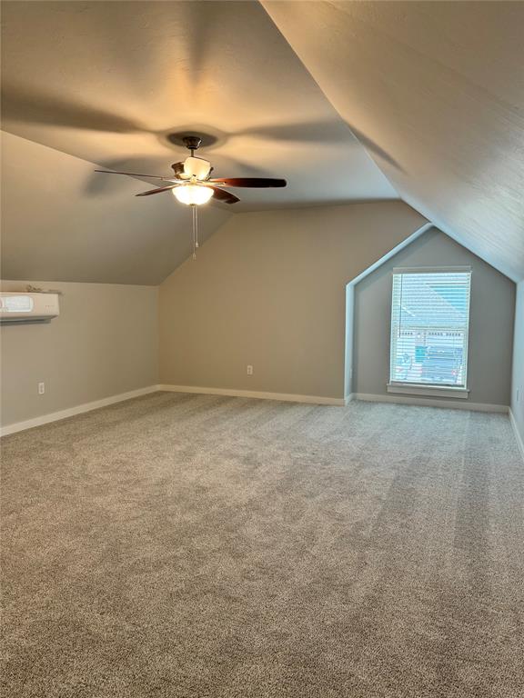 bonus room featuring a wall mounted air conditioner, carpet, ceiling fan, and lofted ceiling