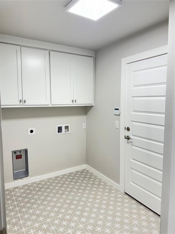 clothes washing area with hookup for a washing machine, cabinets, and electric dryer hookup