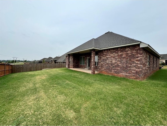 back of property with a patio area and a yard