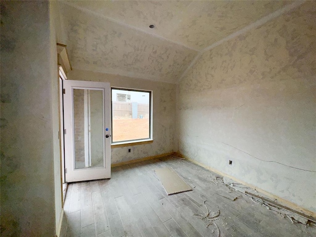 spare room with lofted ceiling and wood finished floors