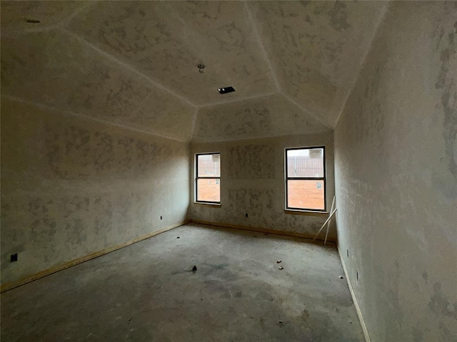 unfurnished room featuring lofted ceiling