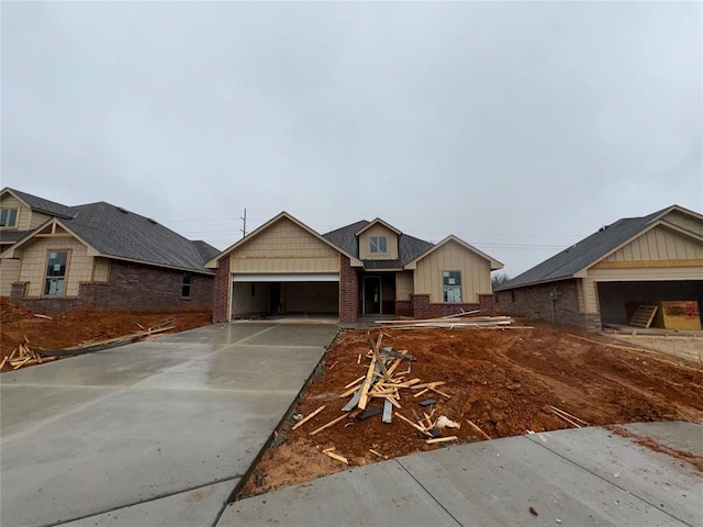 view of front facade with an attached garage, board and batten siding, concrete driveway, and brick siding