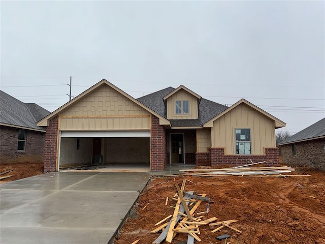 view of front of house featuring brick siding, roof with shingles, concrete driveway, an attached garage, and board and batten siding